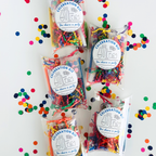 Five BakerCrate Celebration Kit boxes of confetti and shredded paper party supplies on white