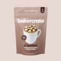 Bakercrate s'mores microwavable mug cake pouch with mini marshmallows and chocolate chips on a mauve background