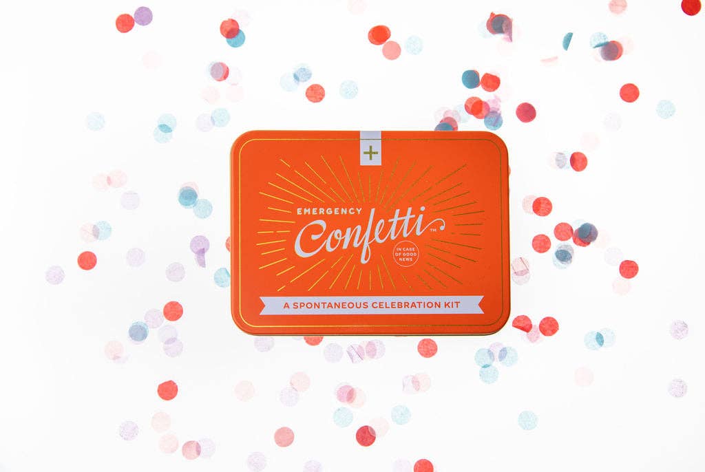Orange Emergency Confetti tin labeled 'A Spontaneous Celebration Kit' surrounded by scattered pastel and red confetti on a white background