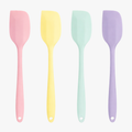 Four mini silicone spatulas in pastel pink, yellow, mint, and purple