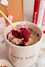 Red velvet mug cake in a Love You mug with a gold spoon and Valentine's Day styling